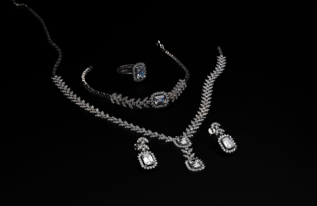 Jewelry set including a necklace, ring, and earrings on a black background